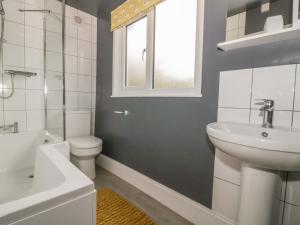 ein Badezimmer mit Waschbecken und Toilette und einem Fenster in der Unterkunft 2 Hillside Cottages in Ipswich + 5 Fotos