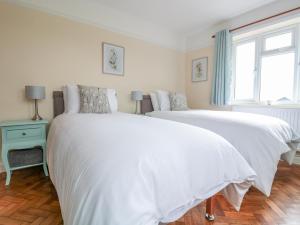 two white beds in a bedroom with a window at Bower View in Hereford