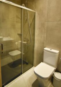 a bathroom with a toilet and a glass shower at Hai Hotel in Larnaca