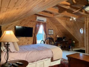 um quarto com uma cama grande num chalé de madeira em The Parrsboro Mansion Inn em Parrsboro