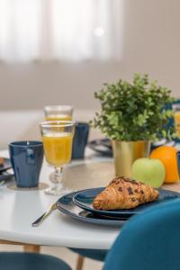 stół z talerzem jedzenia i szklanką soku pomarańczowego w obiekcie Apartments Gordana Jeličić w Hvarze