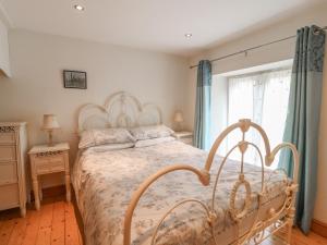 a bedroom with a bed and a window with blue curtains at Forge Cottage in Gainsborough