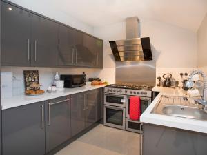uma cozinha com utensílios de aço inoxidável e um lavatório em Hirfron em Llanberis