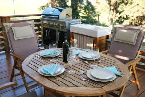 a wooden table with plates and wine glasses on a deck at Limnos Stone House in Kalliópi