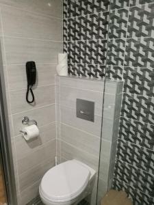 a bathroom with a toilet and a phone on the wall at Golden days in Afantou