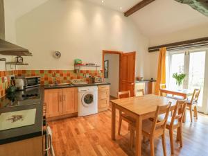 a kitchen with a wooden table and a dining room at Forge Cottage in Gainsborough