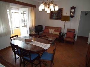 un soggiorno con tavolo, sedie e divano di Casa Zizi Bela a Lourinhã