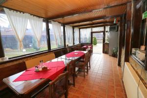 un comedor con mesas de madera y servilletas rojas en Toncho's Guest House for 16 guests, en Arbanasi