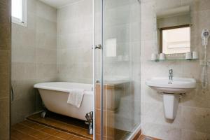 a bathroom with a bath tub and a sink at He Sen B&B in Kenting