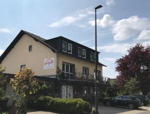 een gebouw waar een auto voor geparkeerd staat bij Residenz Moselzauber - Ferienwohnungen mit Pool Landschaft in Ernst