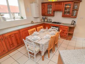a kitchen with a table and chairs in a kitchen at Magpie Cottage in Wooler