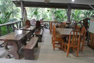 a restaurant with wooden tables and wooden chairs at Khaosok Island Resort in Khao Sok National Park