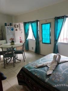 1 dormitorio con cama, mesa y cortinas azules en Tierra del sol en Guaymallén