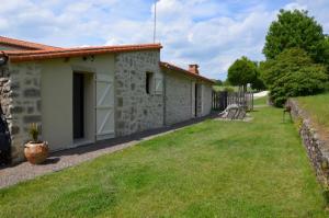 uma pequena casa de pedra com um quintal em La Remise 4 étoiles em Saint-Hilaire-de-Mortagne