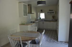 uma cozinha com mesa e cadeiras num quarto em La Remise 4 étoiles em Saint-Hilaire-de-Mortagne