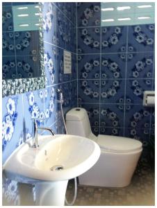 y baño con lavabo, aseo y azulejos azules. en New Hut Bungalow, en Lamai