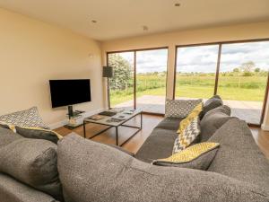 a living room with a large couch and a television at Rose Lodge in York