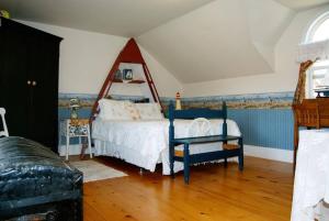 1 dormitorio con 1 cama y 1 silla en Bugaboo Cottages en Summerside