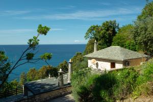 a house on a hill with the ocean in the background at Pelion BNB Luxury homes in Damouchari