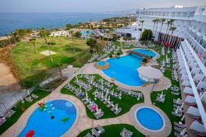 an aerial view of a resort with two pools and chairs at Leonardo Laura Beach & Splash Resort in Paphos