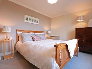 a bedroom with a large bed and two lamps at Maes y Cregyn in Llanallgo