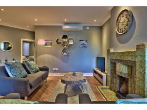 uma sala de estar com um sofá e uma lareira em Greenpoint Apartments em Cidade do Cabo