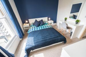 a bedroom with a bed and a desk and a window at St Stephens Road Apartment in Norwich