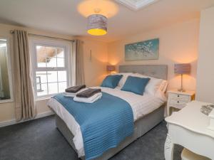 a bedroom with a large bed and a window at Cedarwood Cottage in Winkleigh