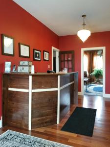 un bureau avec des murs rouges et un bureau en bois dans l'établissement The Parrsboro Mansion Inn, à Parrsboro