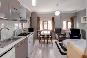 Una cocina y una sala de estar con mesa y sillas. en Masal Apart, en Estambul