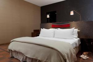 a large bed with white pillows in a hotel room at Nayara Alto Atacama in San Pedro de Atacama