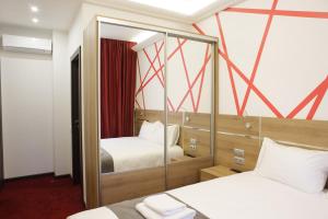 a hotel room with two beds and a mirror at KANNA in Moscow