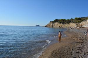 a man walking on a beach near the water at Limeri Traditional Guest House in Monólithos