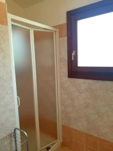 een douchecabine in een badkamer met een raam bij Residence Le Ginestre / Ataras in Porto San Paolo +24 foto's