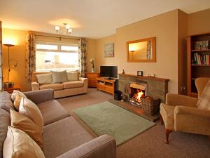 a living room with a couch and a fireplace at Mor Edrin in Criccieth
