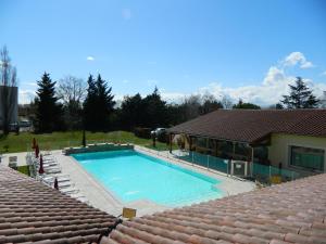 een groot zwembad naast een huis bij Hotel Restaurant La Martiniere in Montélier