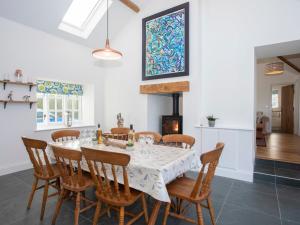 a kitchen and dining room with a table and chairs at Mwythus in Rhoscolyn