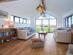 a living room with two couches and a table at Mwythus in Rhoscolyn