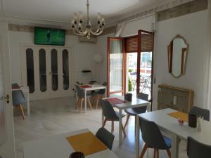 una sala de estar con mesas, sillas y una lámpara de araña. en La Dimora del Conte en Pescara