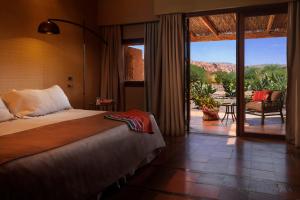 a bedroom with a bed and a view of a patio at Nayara Alto Atacama in San Pedro de Atacama