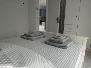 two stacks of towels on a bed in front of a mirror at Athani Summer House (Apartments 01 - 02) in Athanion