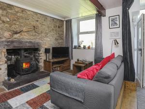 a living room with a couch and a fireplace at Tan Meredydd in Nantlle