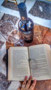 een persoon die een boek leest met een fles en een glas bij R&G Salento in Porto Cesareo