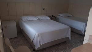 una camera con due letti e un cestino di Hotel Maringa a Maringá