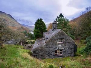 an old stone house on the side of a hill at Pantlleni in Beddgelert