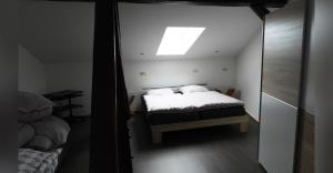 a small bedroom with a bed and a skylight at Ferienwohnung Olafs Werkstatt in Neustadt +3 photos
