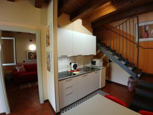 a kitchen with white cabinets and a stair case at Haus Colà in Colà di Lazise