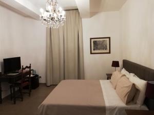 Schlafzimmer mit einem Bett, einem Schreibtisch und einem Kronleuchter in der Unterkunft DreaMilan B&B in Mailand