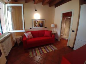 a living room with a red couch and a window at Haus Colà in Colà di Lazise