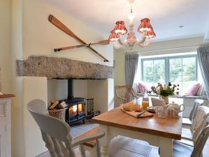 a dining room with a table and a fireplace at Penrhyn Farm in Penrhos-Lligwy